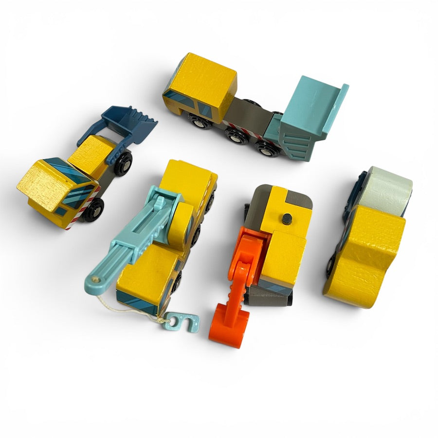 A view from the top of a set of 5 Tender Leaf Wooden Construction Vehicles in yellow and blue including a dump truck, front loader, excavation digger, crane truck, road roller against a white background.