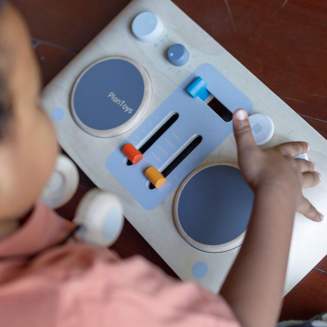 Child plays with Plan Toys DJ Mixer Board