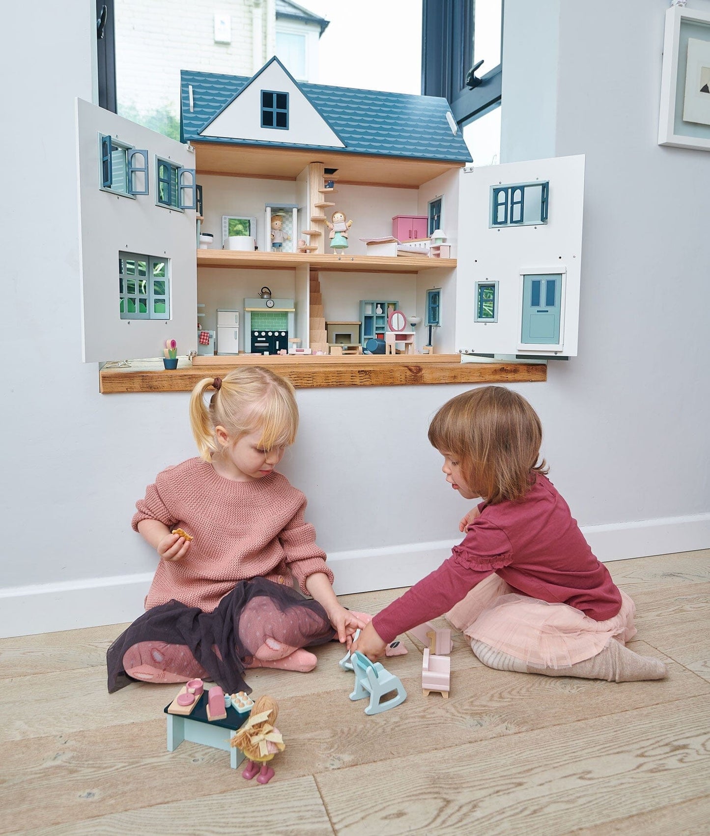 Two kids play with Tender Leaf Dollhouse Dovetail House