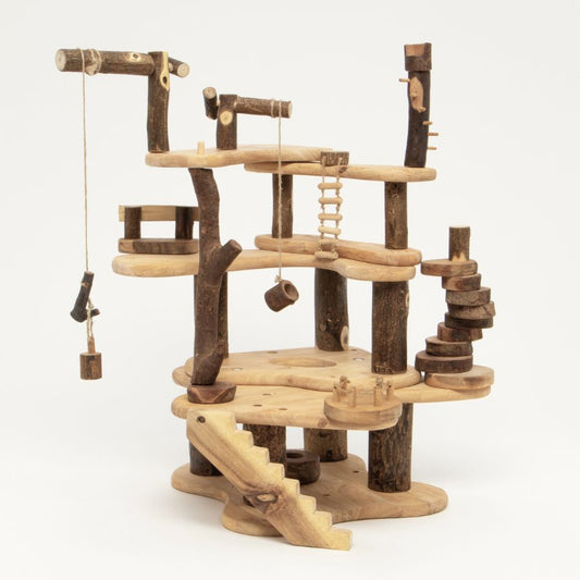 A Tree Blocks Build a Treehouse play structure made from natural logs and light wood boards, featuring platforms, stairs, hanging ropes, and small wooden toys, photographed on a clean white background.