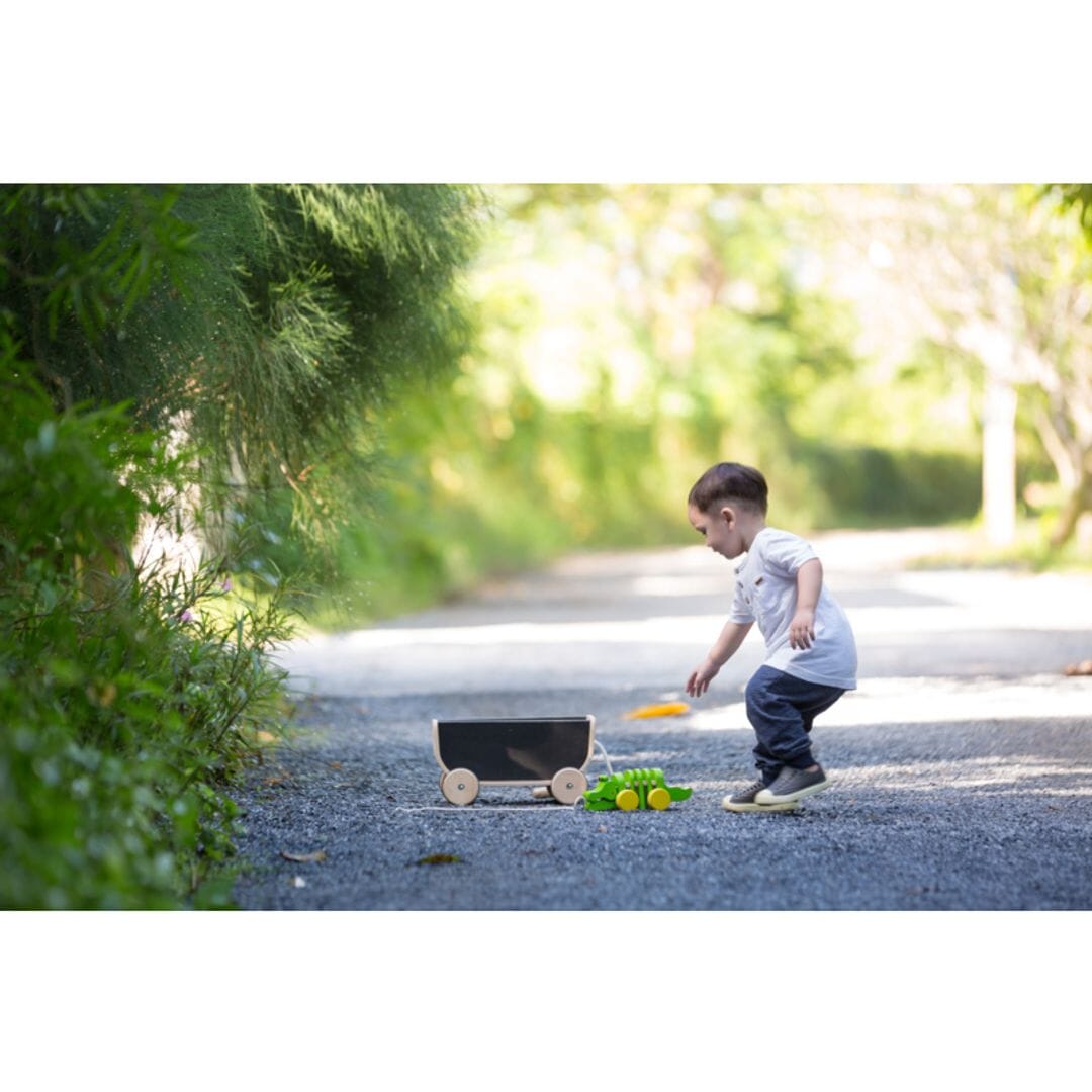Toddler plays with little wagon toy