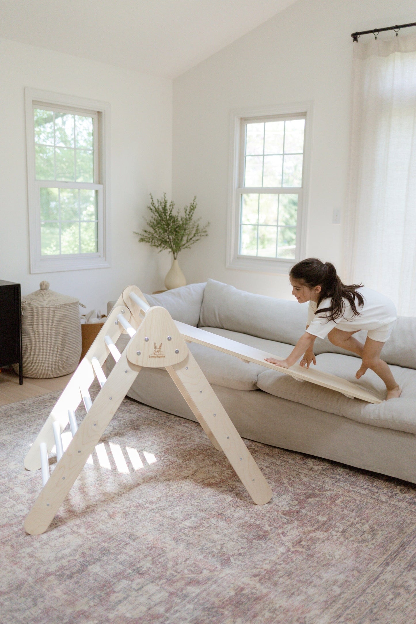 Child plays on Bunny Hopkins Pikler Climbing Triangle with slide