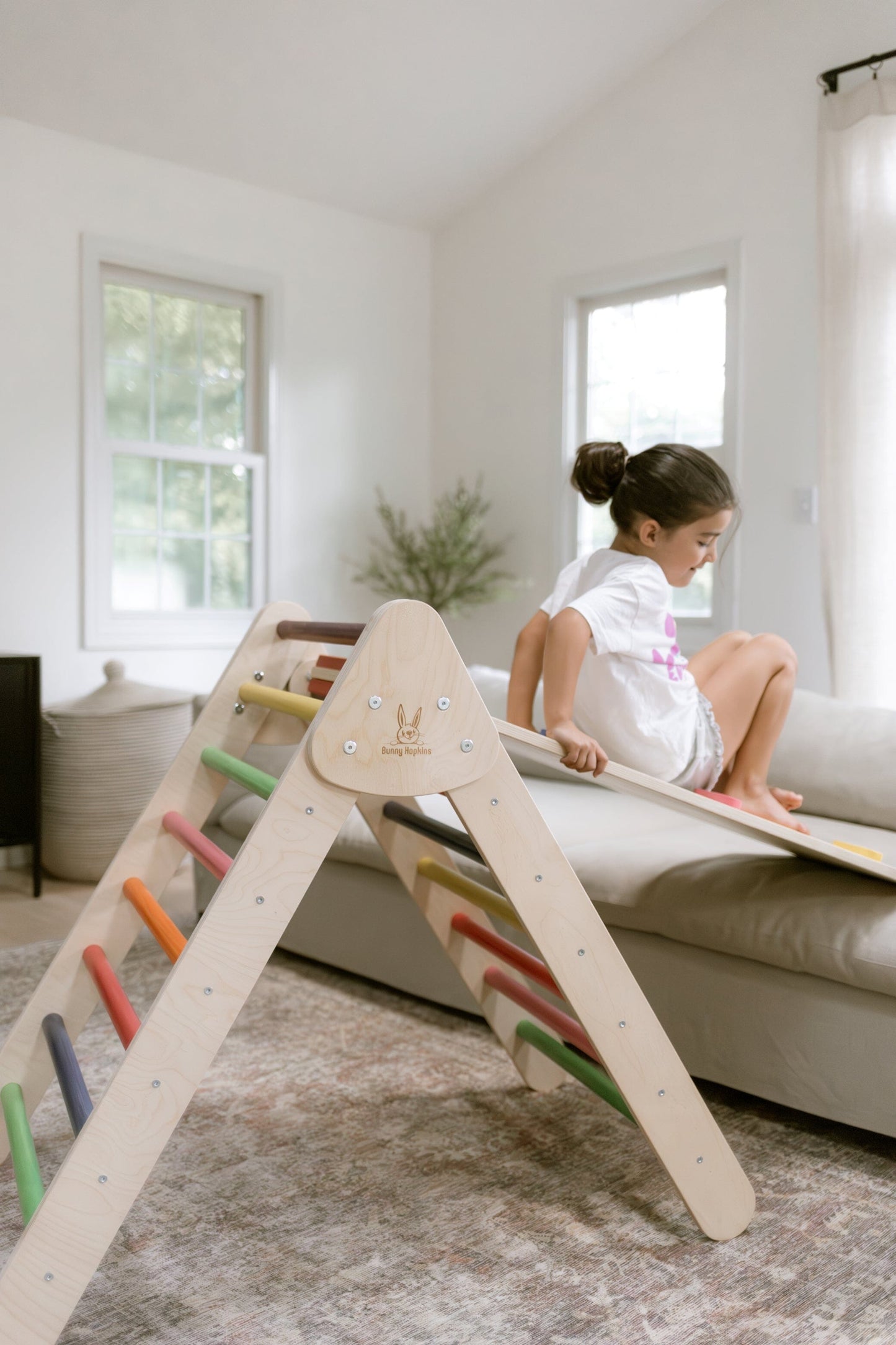 Child plays on Bunny Hopkins Pikler Climbing Triangle with slide