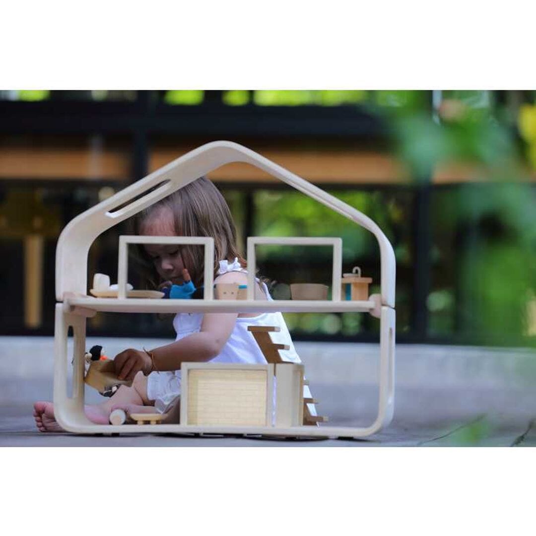 Child plays with Mid century modern dollhouse with furniture