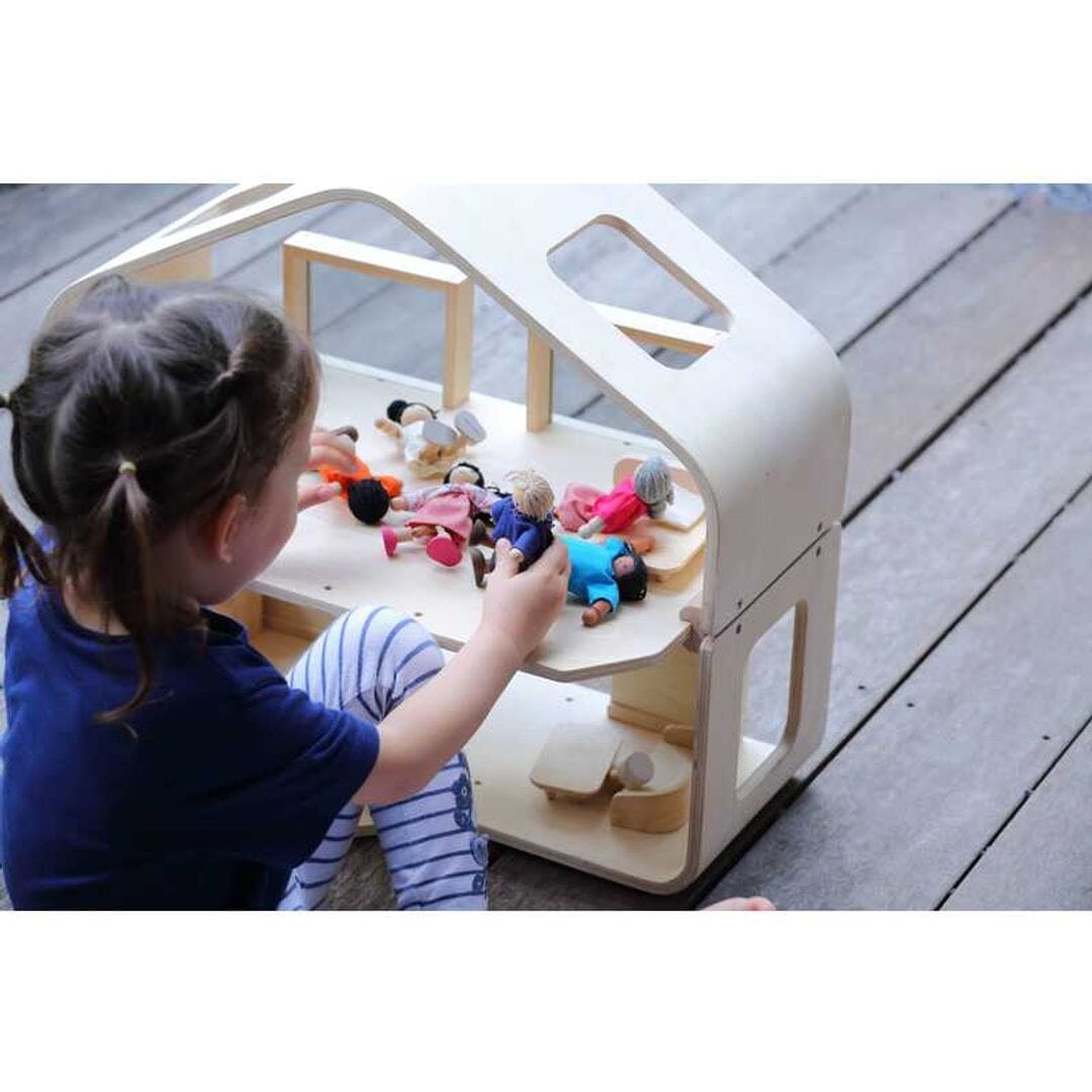 Child plays outside with Mid century modern dollhouse with furniture