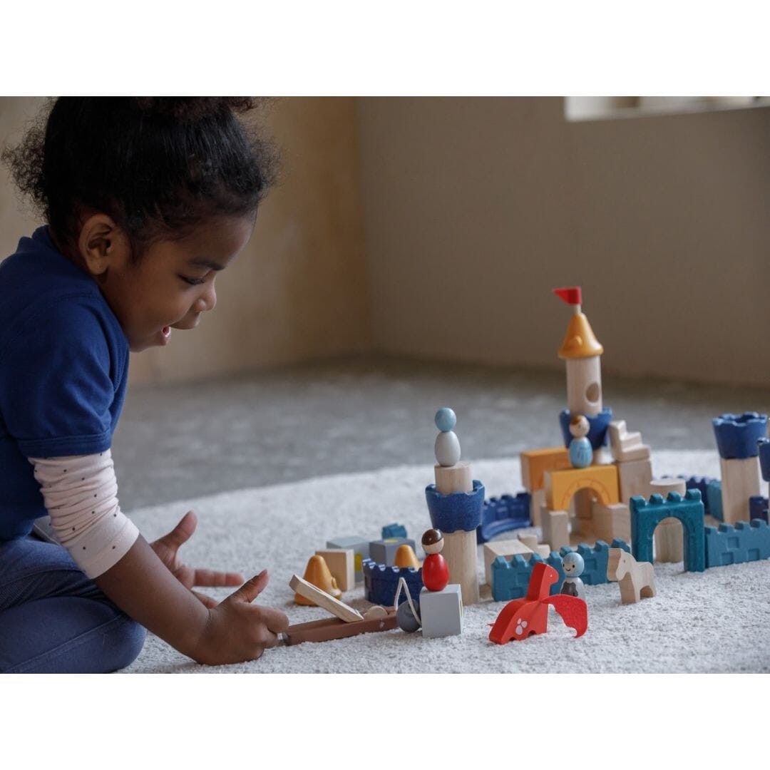 Girl plays with Wooden Building Blocks Castle from PlanToys