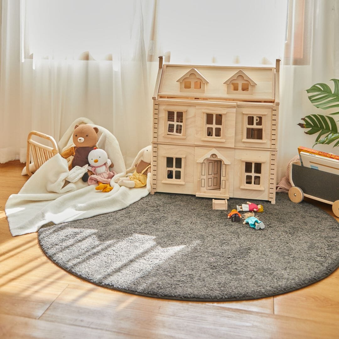 Large Victorian dollhouse with a natural finish as seen in the playroom.