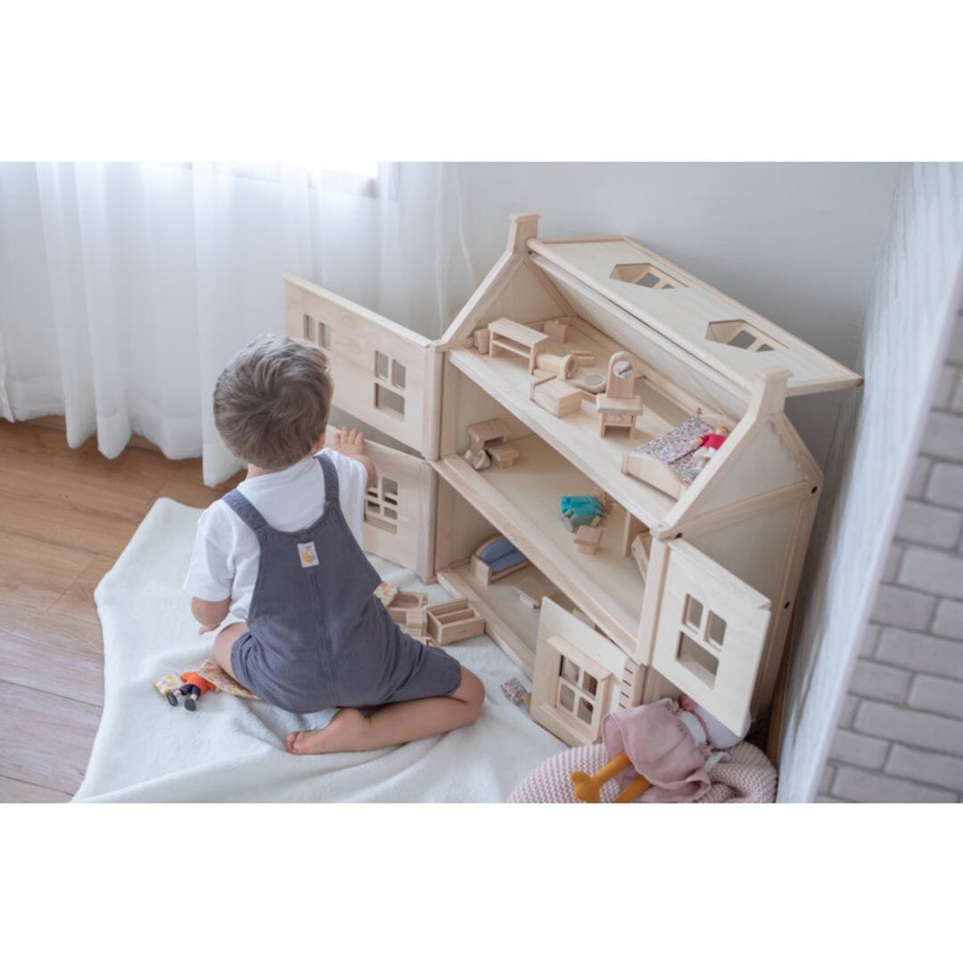 Child plays with neutral-gender Victorian dollhouse from PlanToys.