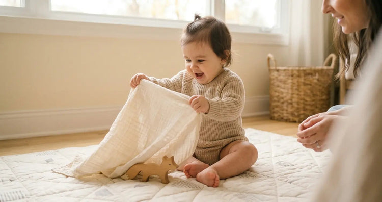 Baby lifting a cloth to discover a hidden toy, showing delighted surprise during a peekaboo game