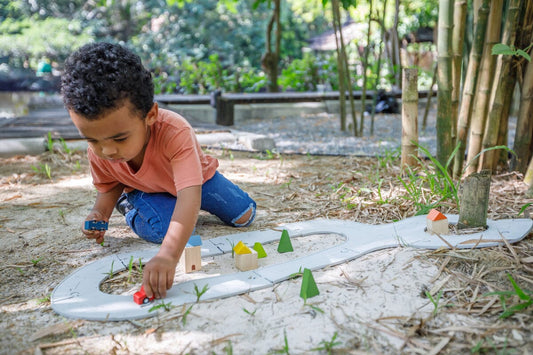 Flexible toy road set from PlanToys - boy plays outdoors