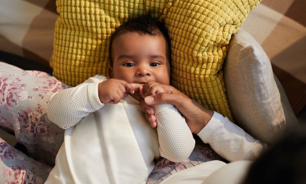 Baby with teething pain sucks on mother's finger help soothe teething pain