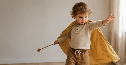 Toddler in colorful dress-up costume, deeply absorbed in pretend play with focused expression