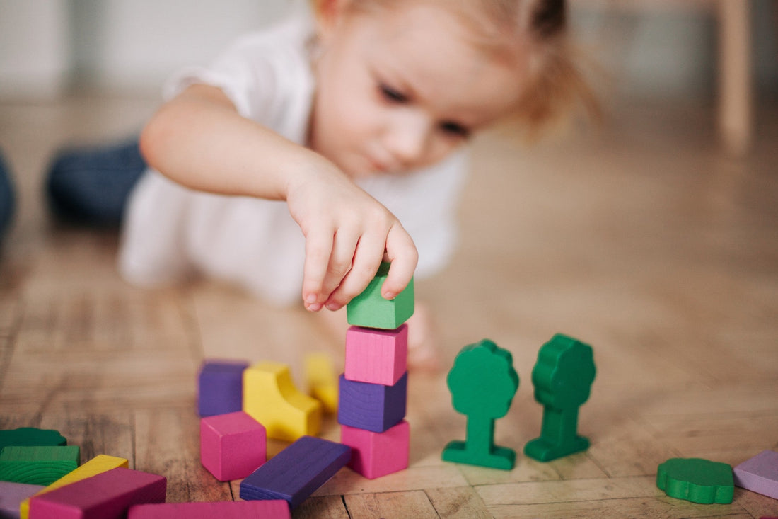 Girl plays with wooden blocks in how to care for wooden toys