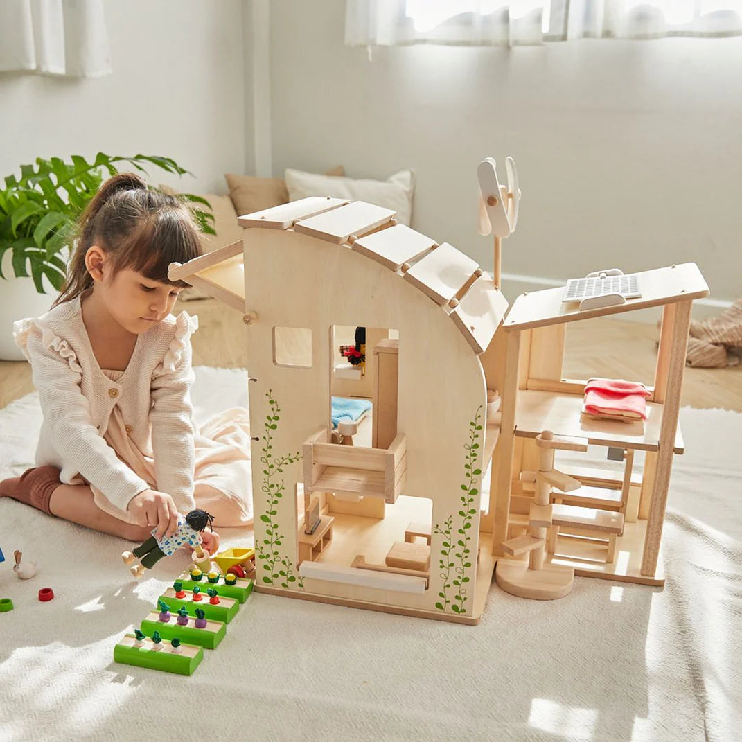 Child plays with green dollhouse