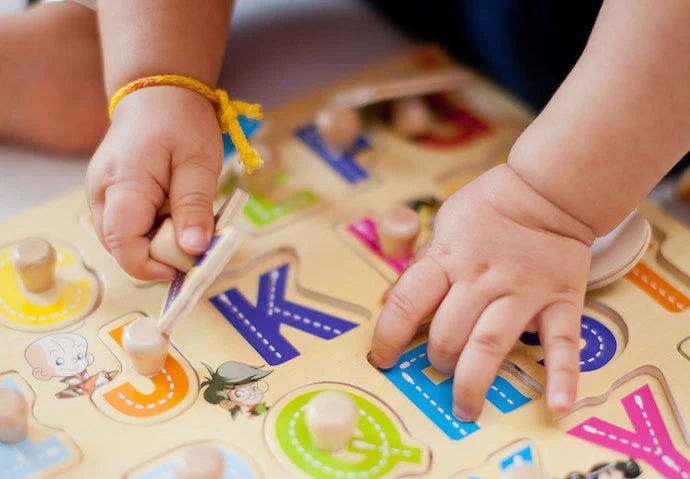 Child playing with wooden alphabet puzzle - used toddler learning toys