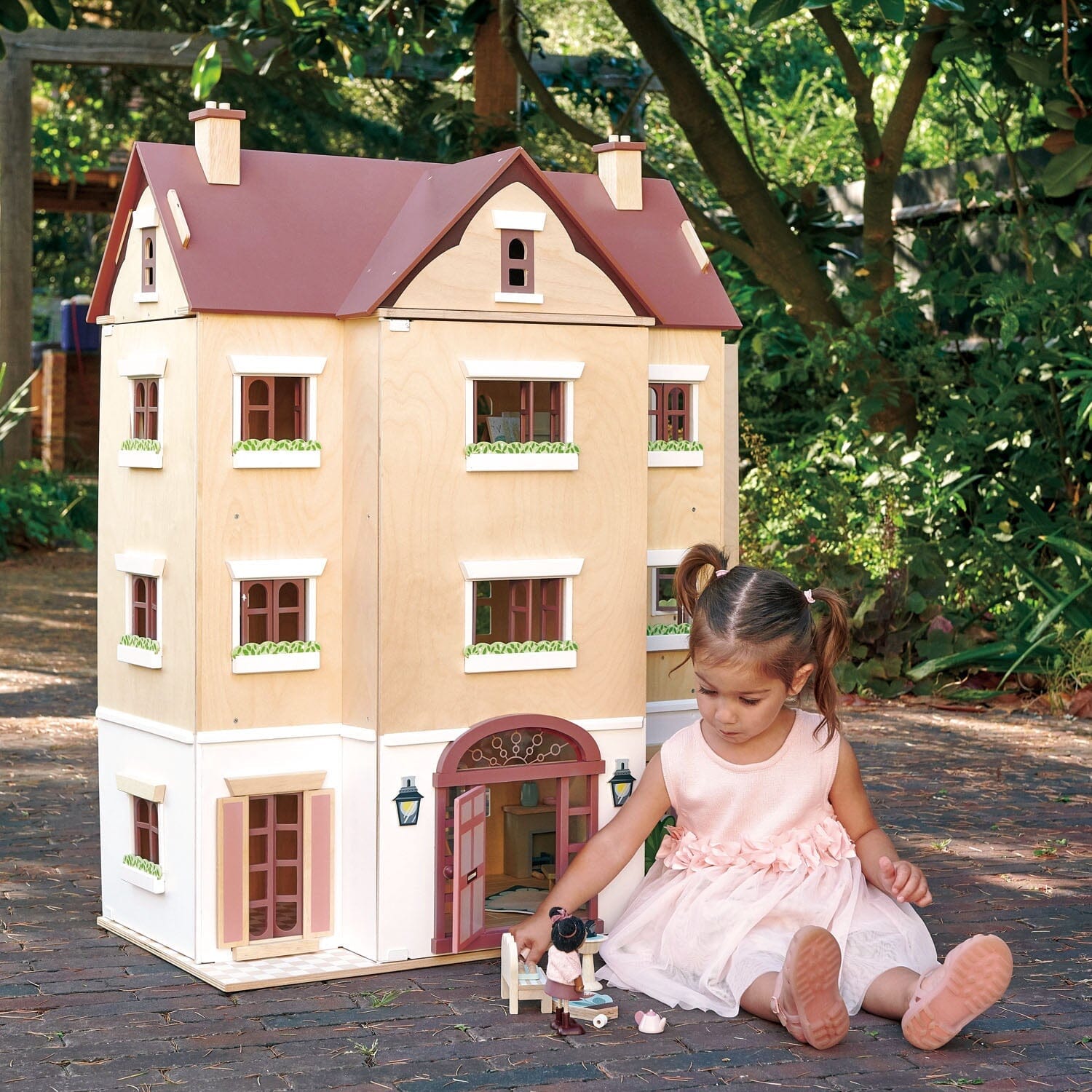 Child playing with 3 story dollhouse