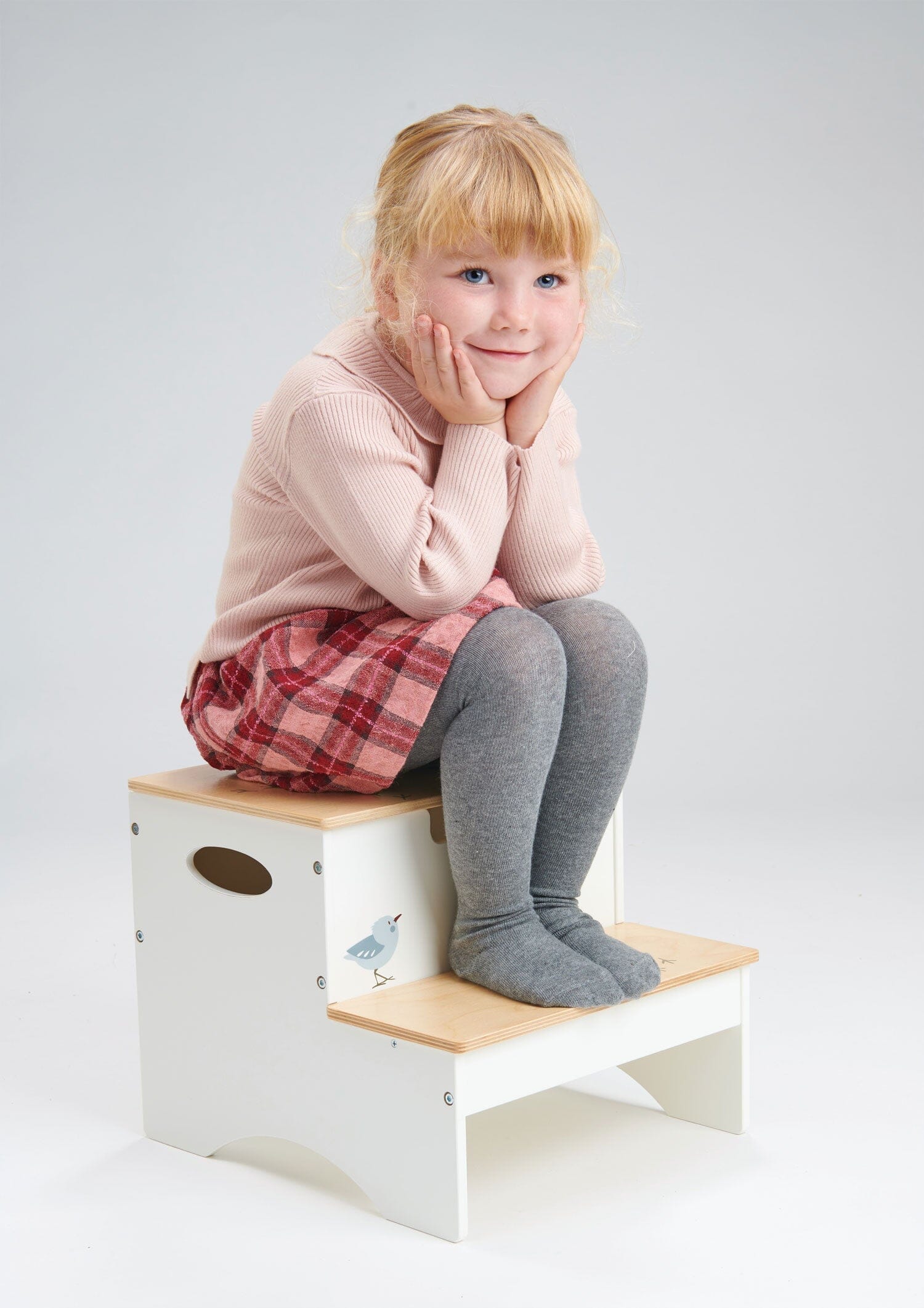Child seated on Forest Steps Childrens Wooden Step Stool with storage compartment