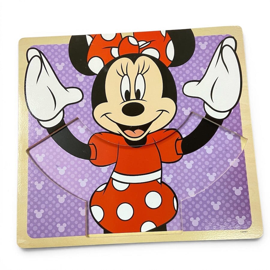 A wooden children's puzzle featuring Minnie Mouse on a purple patterned background with a light wood border.