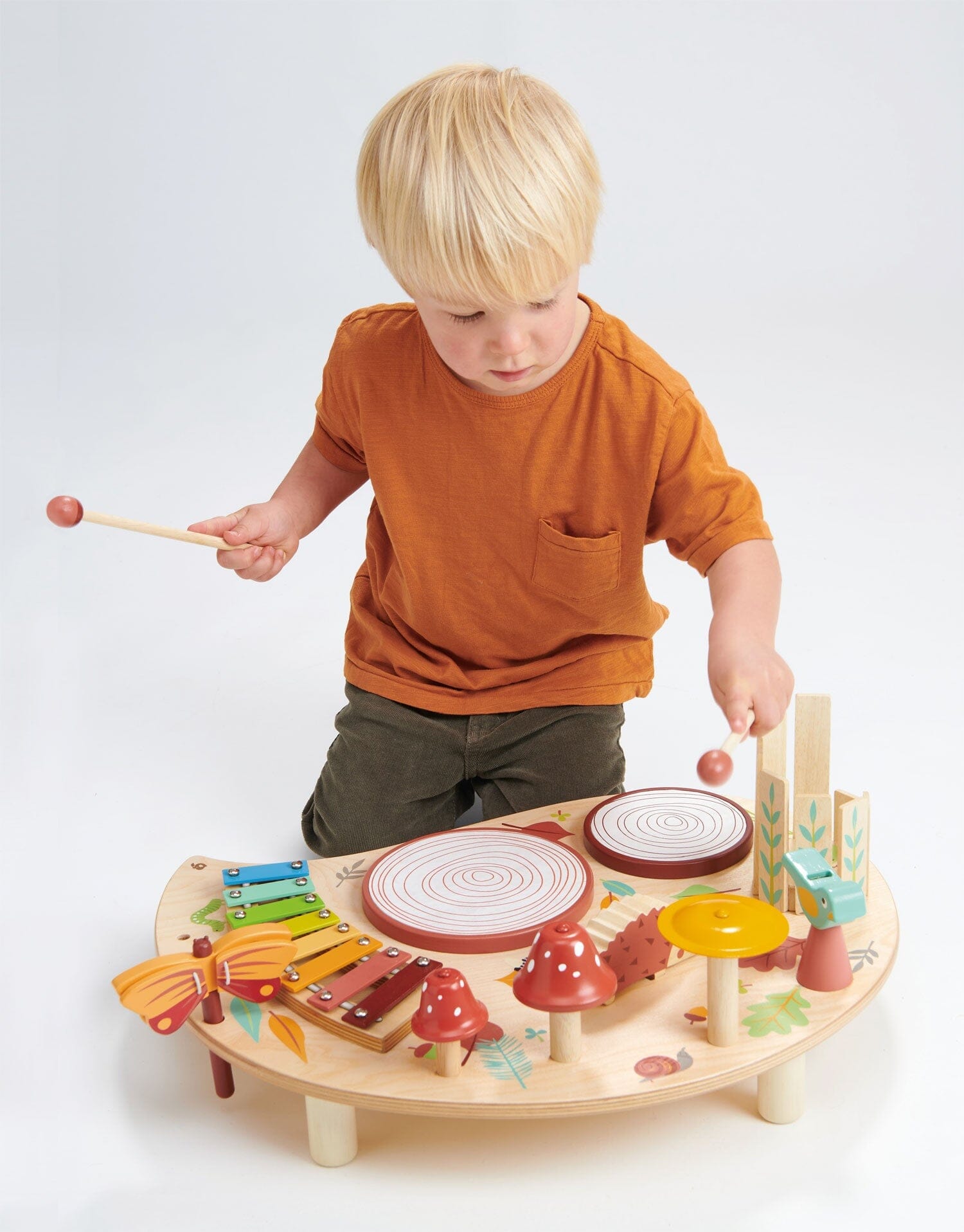 Child taps cymbal from TenderLleaf Toys Musical Table 