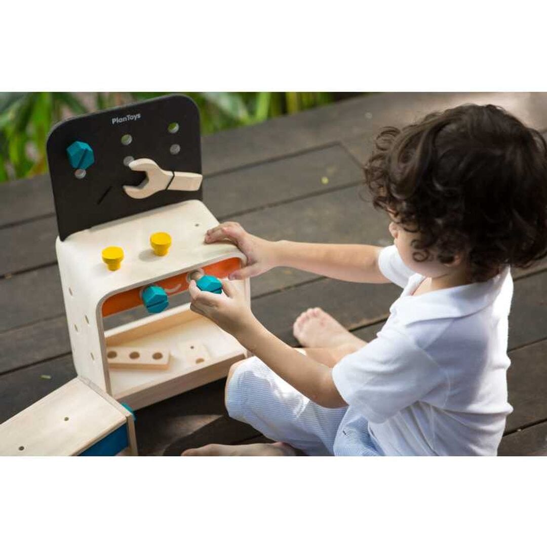 Child plays with Childrens toy work bench from PlanToys