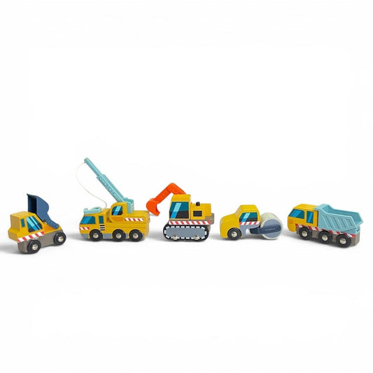 A set of 5 Tender Leaf Wooden Construction Vehicles in yellow and blue lined up in a row including a dump truck, front loader, excavation digger, crane truck, road roller against a white background.