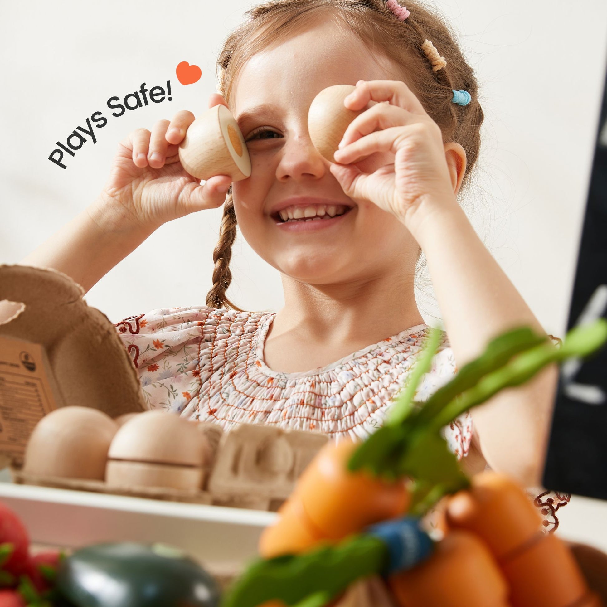 Girl smiles and plays with Tiny Land® Wooden Play Food Set