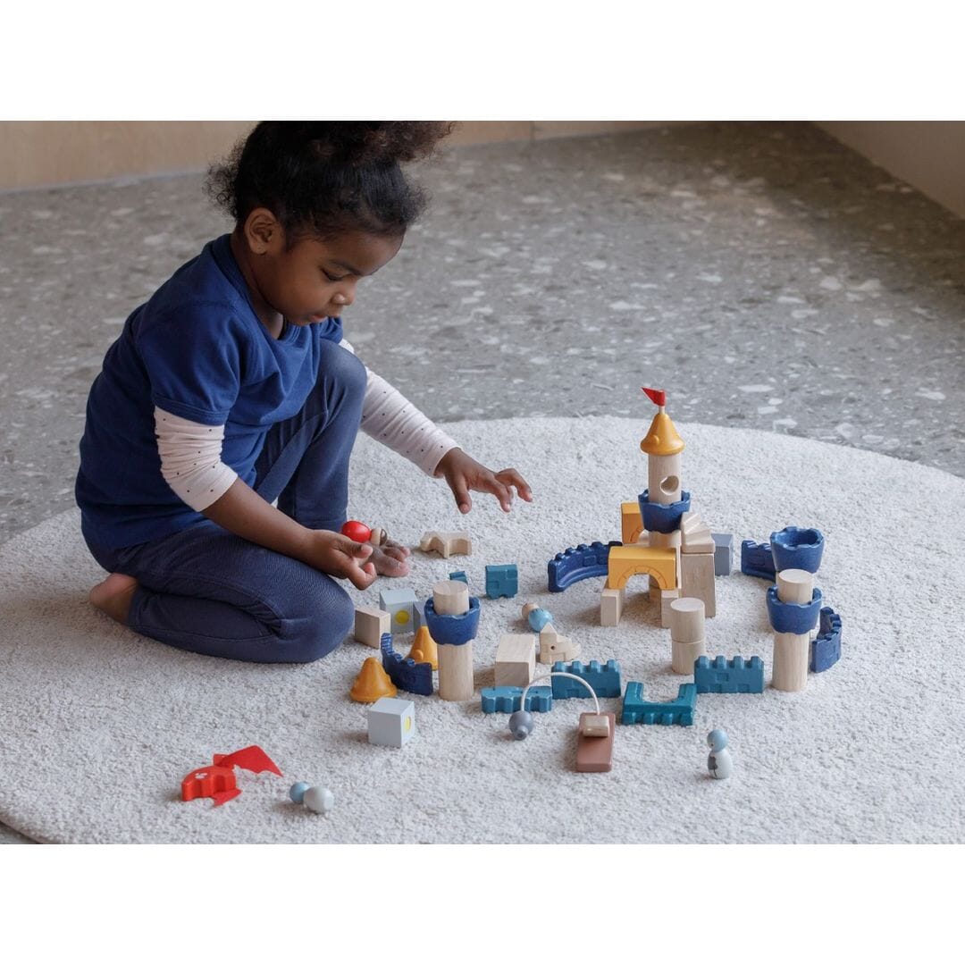 Child plays with Wooden Building Blocks Castle from PlanToys