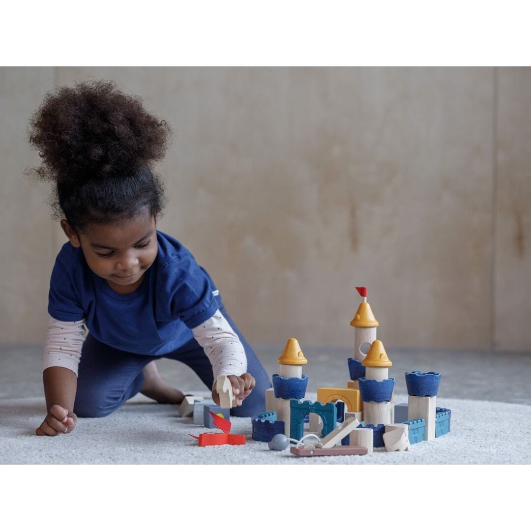 Child plays with Wooden Building Blocks Castle from PlanToys - frontal shot