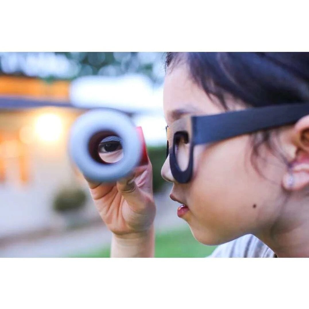 Girl looks through spy glass from the PlanToys Detective Set Toys 