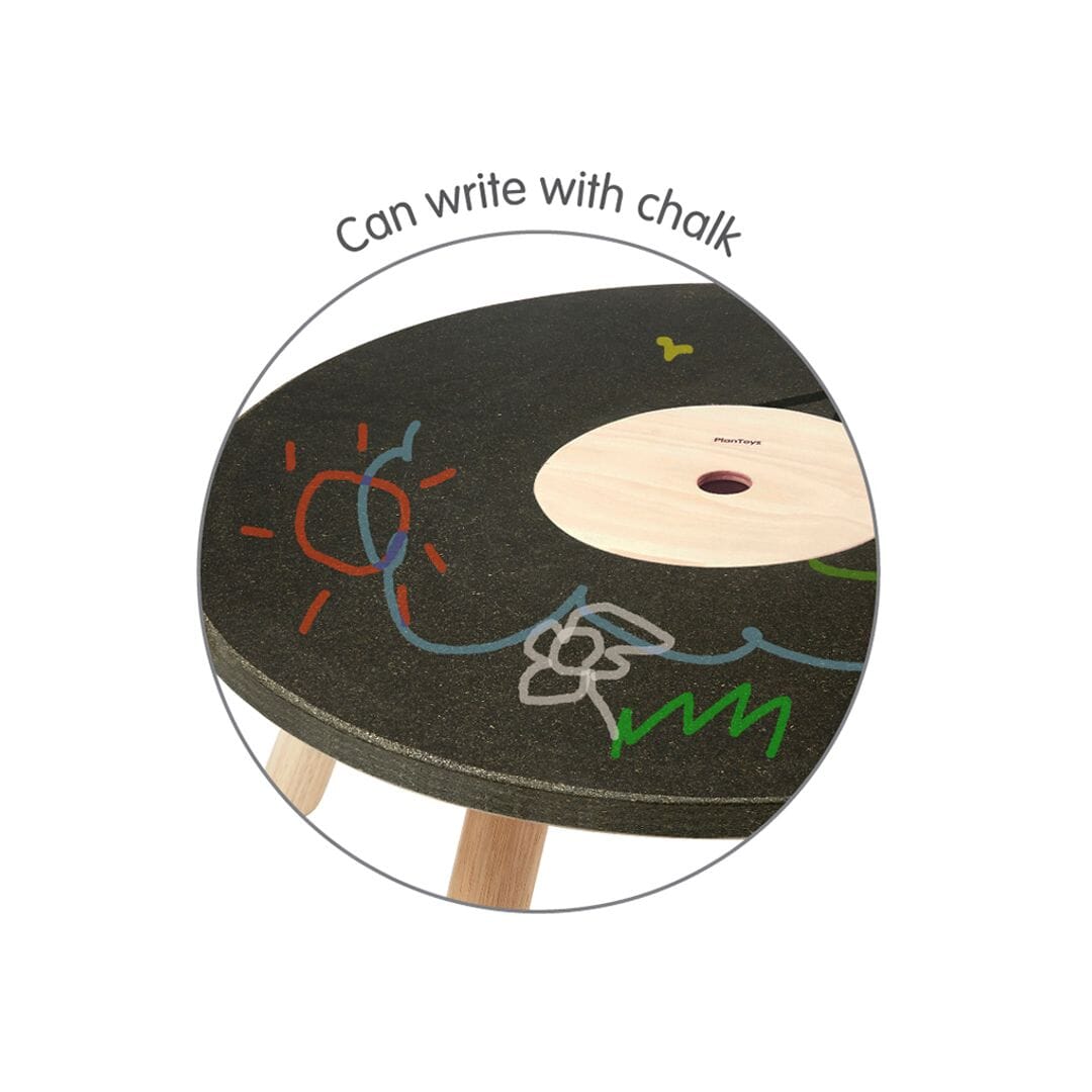 Close up cut out of PlanToys wooden round table with erasable writing surface - can write with chalk.