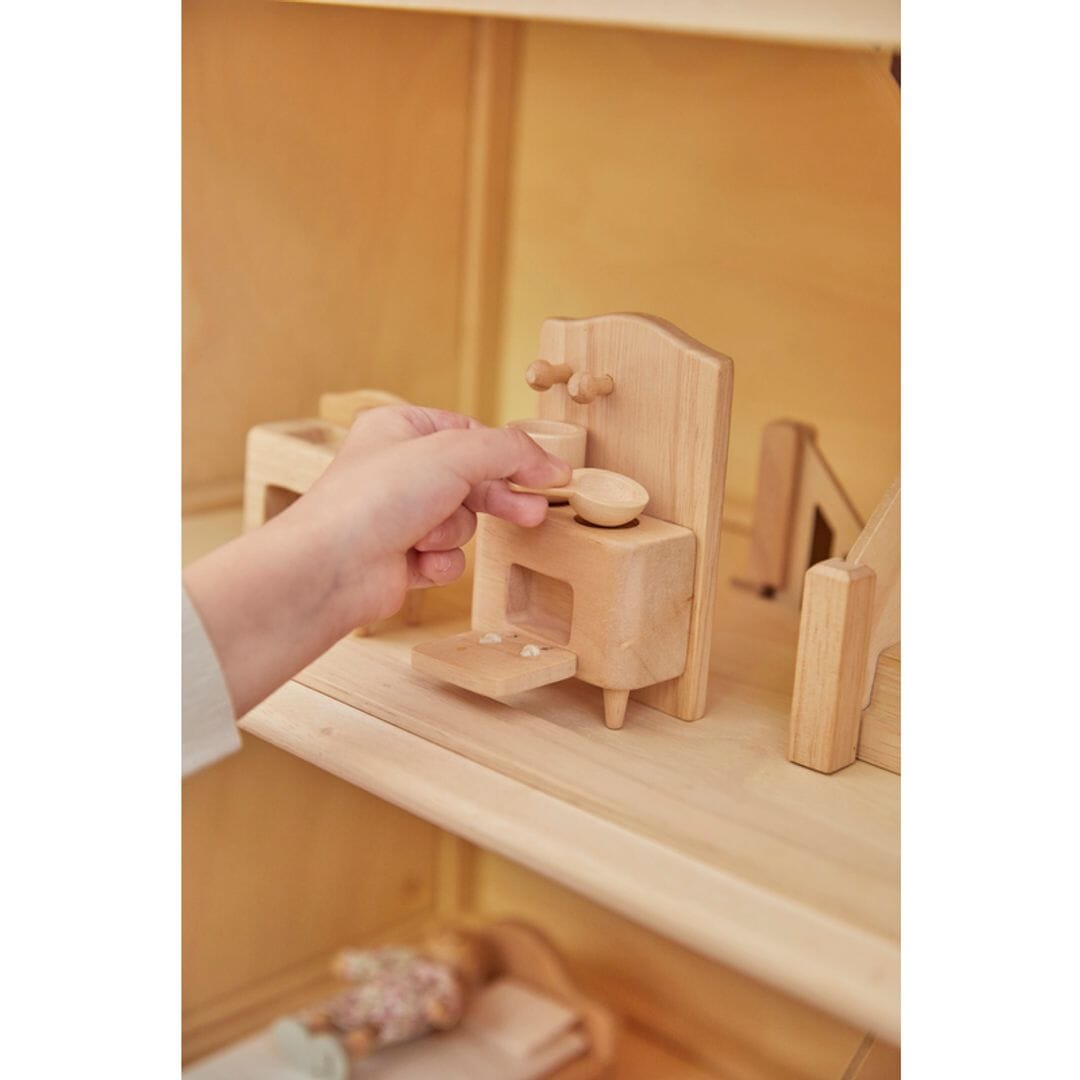 Child plays with PlanToys Victorian wooden kitchen set - all natural unfinished wood. 